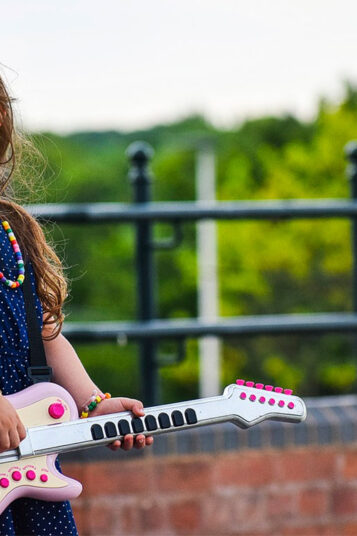 Une petite fille avec sa guitare jouet rose